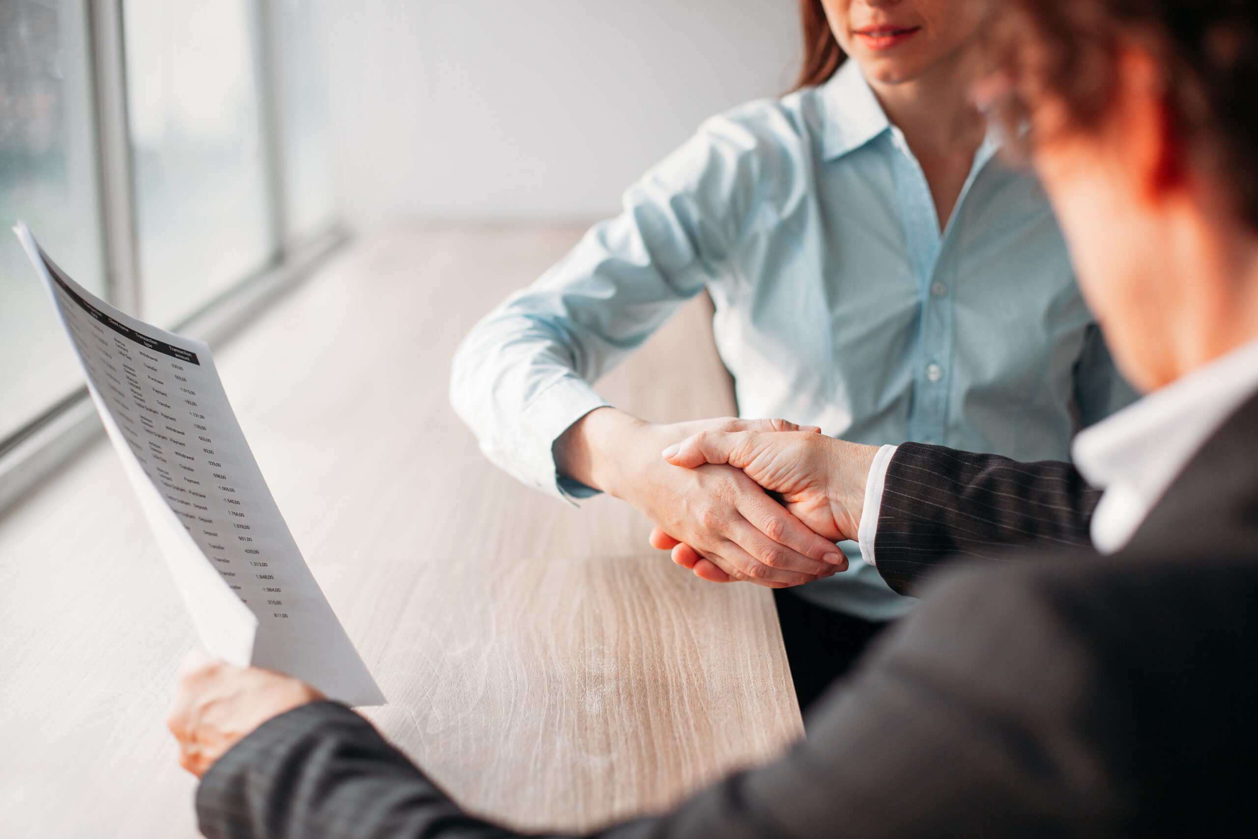 Women shaking hands after signing of contract
